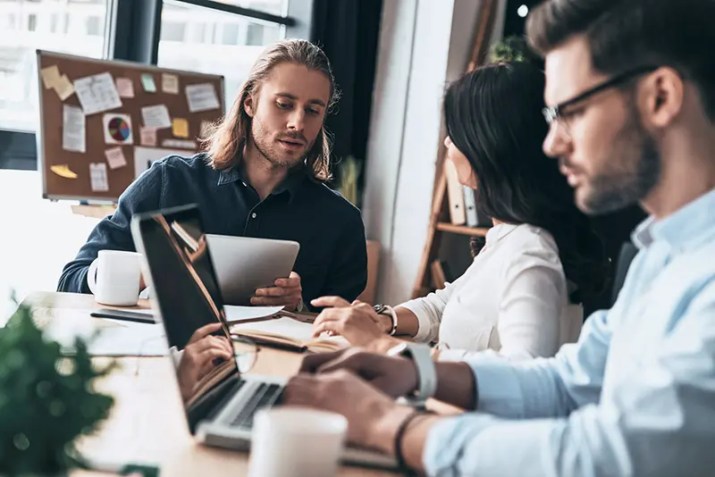 Pleasant working day. Young modern colleagues in smart casual wear working while spending time in the office